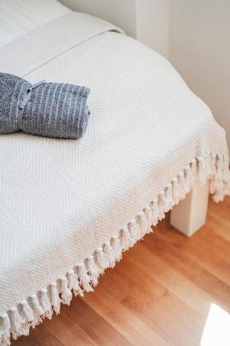 a white bed with a blue pillow on it at Central City Suits in Wiener Neustadt