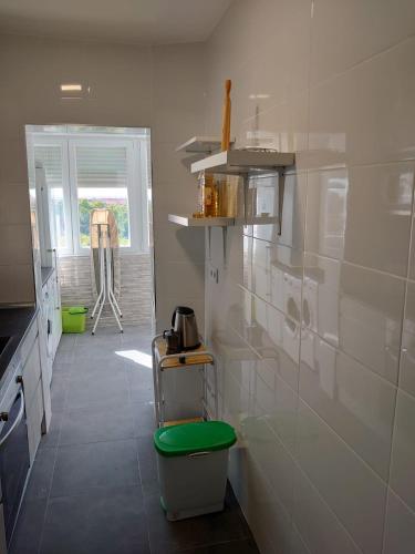 a kitchen with white walls and a green stool at Apartamento de 3 habitaciones in Getafe