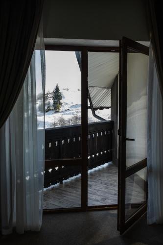 a door to a balcony with a view of a snow covered yard at Синевирський Перевал in Synevyr