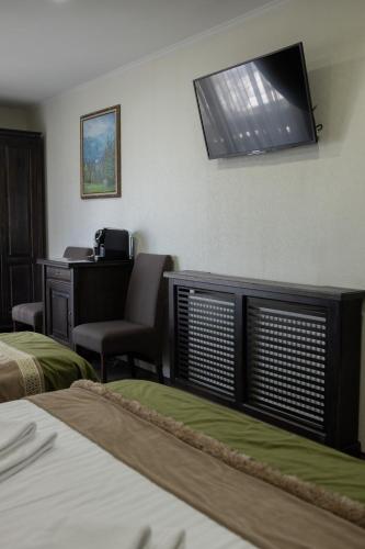 a hotel room with a desk and a television on the wall at Синевирський Перевал in Synevyr