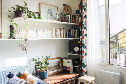 une pièce avec un banc et des étagères avec des livres dans l'établissement Renovated apartment for 4 people, à Pantin