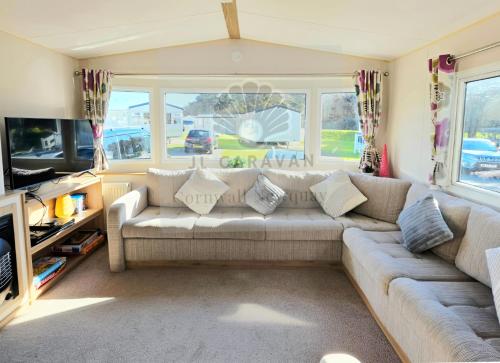 a living room with a couch and a tv at JL Cornwall Newquay Caravan in Newquay