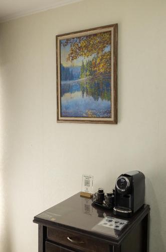 a picture of a painting on the wall above a table at Синевирський Перевал in Synevyr