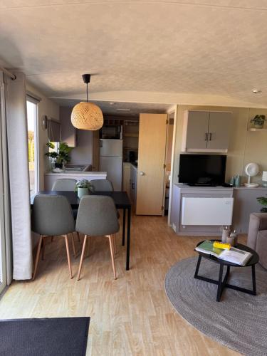 a living room with a table and a kitchen at Modern Chalet nabij Ijsselmeer met mooi buitenzwembad op sfeervolle camping in Warns