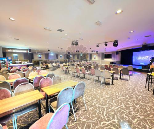 a banquet hall with tables and chairs and a stage at JL Cornwall Newquay Caravan in Newquay