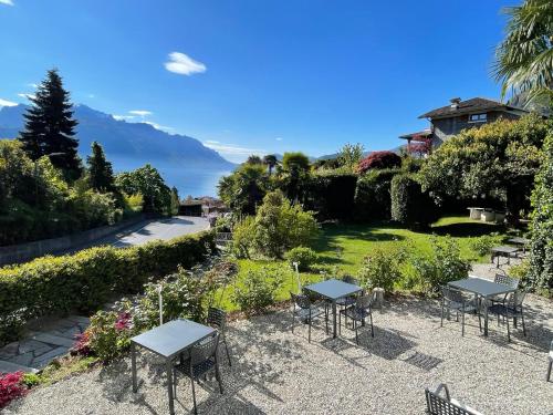 a patio with tables and chairs in a garden at Hotel Loveno in Menaggio