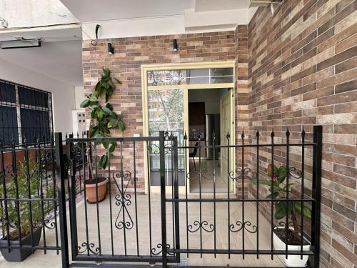a black iron fence in front of a brick building at Palm Side Hotel in Vlorë
