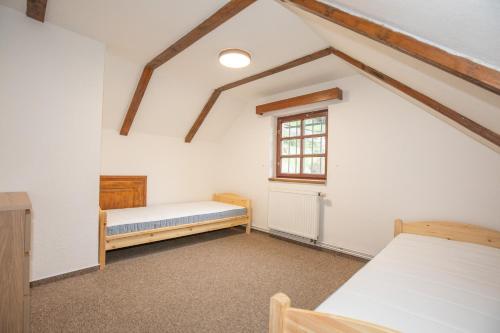 a attic room with two beds and a window at Resort U Jelena in Křivoklát
