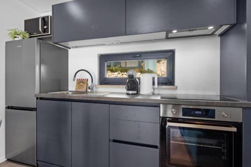 a kitchen with a sink and a stove at Sea view Anika by Vellaris, Luxury Mobile Home in Mali Lošinj