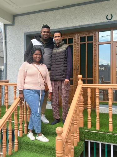 three people standing on the stairs of a house at Moonshine Homestay Kashmir in Srinagar