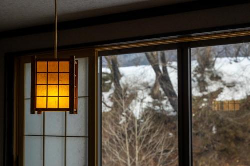 a chandelier is hanging in front of a window at Fujisan Ryokan in Hanamaki