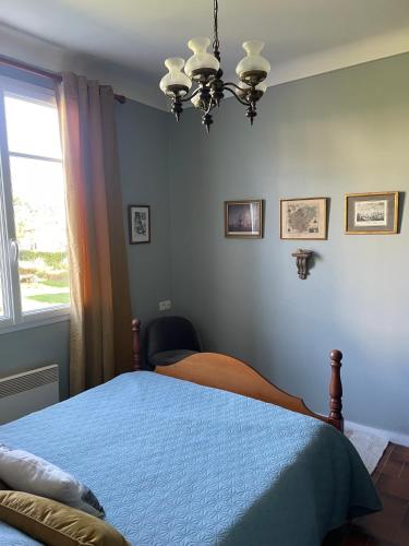 a bedroom with a blue bed and a window at " Goarem Bihan" Villa de Charme Front de Mer in Plouarzel
