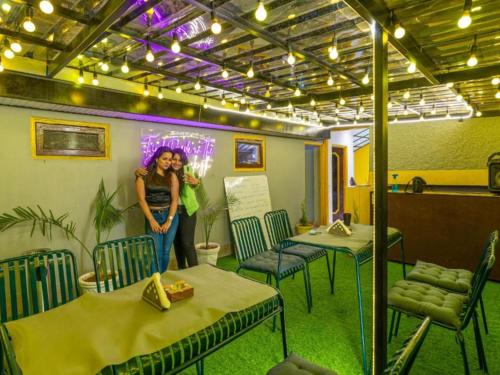 a woman standing in a room with tables and chairs at The Hosteller Shimla in Shimla