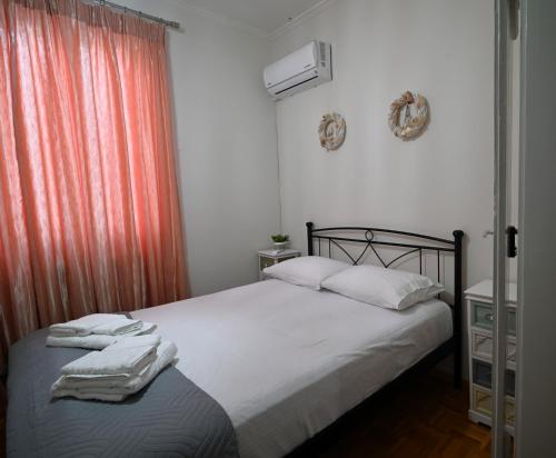 a bedroom with a bed with white sheets and a window at Dora's House in Chios