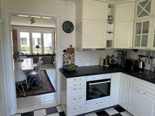 a kitchen with white cabinets and a black counter top at Kåsebergahuset in Löderup