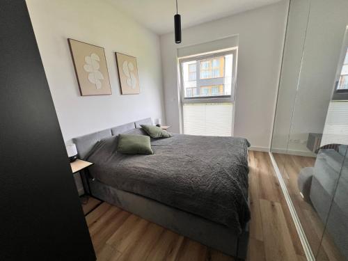 a bedroom with a bed and two windows at Apartament Park Trzy Stawy in Katowice