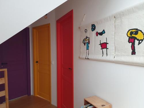a hallway with two doors and a painting on the wall at Chambres et petit déjeuners in Courcemont