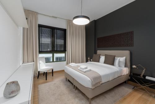 a bedroom with a large bed and a chair at La Sirene 1, Port De La Mer - Mint Stay in Dubai