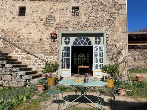 a table and chairs in front of a building at Château du Bouy in Champétières