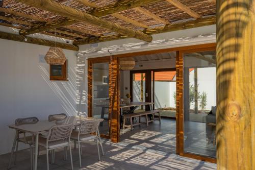a dining room with a table and chairs on a patio at Pestana Comporta Village Residences in Comporta