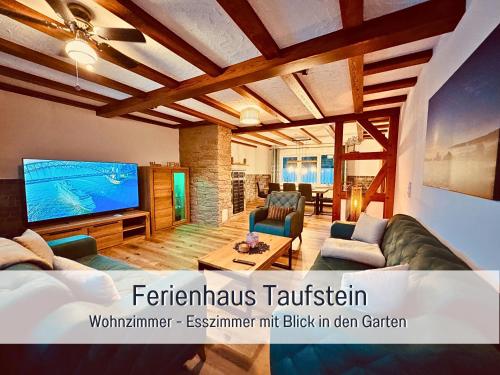 a living room with a large flat screen tv at Familientreffen - Ganzes Haus - Spielplatz - Spielzimmer - Garten - Scheune - Terasse - Grill - Ferienhaus Taufstein in Herbstein