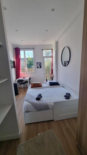 une chambre avec un grand lit blanc dans une pièce dans l'établissement Studio Beitz Calme Proche Gare, à Bordeaux