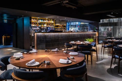 a restaurant with tables and chairs and a bar at The Blue by Just Inn in Taipei