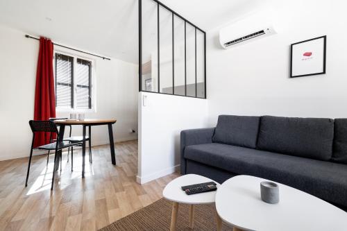 un salon avec un canapé et une table dans l'établissement LE COCON ROSE - Hyper-centre - Cozy - WIFI & Netflix, à Toulouse