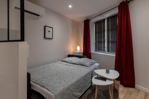 une petite chambre avec un lit et une table dans l'établissement LE COCON ROSE - Hyper-centre - Cozy - WIFI & Netflix, à Toulouse