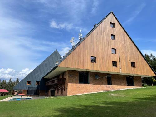a large brick barn with a gambrel roof at Apartmán Žalý in Benecko