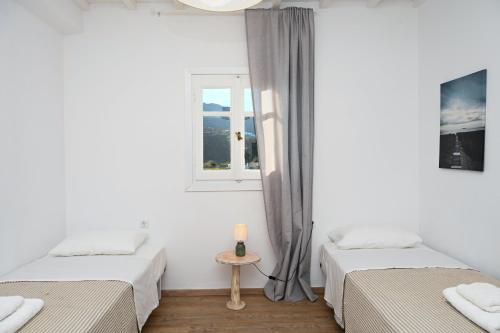 two beds in a room with a window at MZ Mykonos Rock in Pánormos