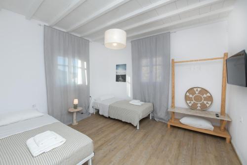 a white room with two beds and a tv at MZ Mykonos Rock in Pánormos