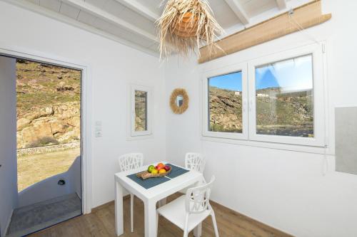 a white room with a table and chairs and windows at MZ Mykonos Rock in Pánormos