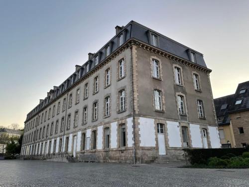 ein großes Backsteingebäude mit vielen Fenstern in der Unterkunft El pisito Quimperois duplex 2 chambres coeur de ville in Quimper