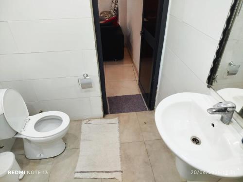 a bathroom with a toilet and a sink at Ecrin de douceur chic en ville in Lomé