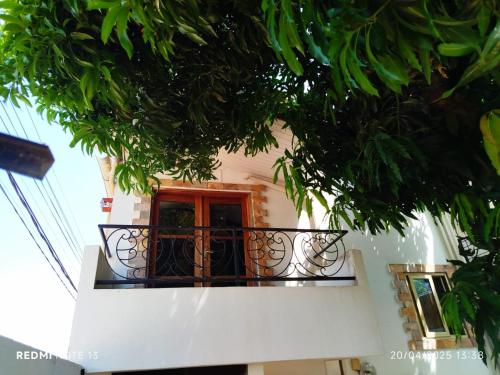 a building with a red door and a balcony at Ecrin de douceur chic en ville in Lomé