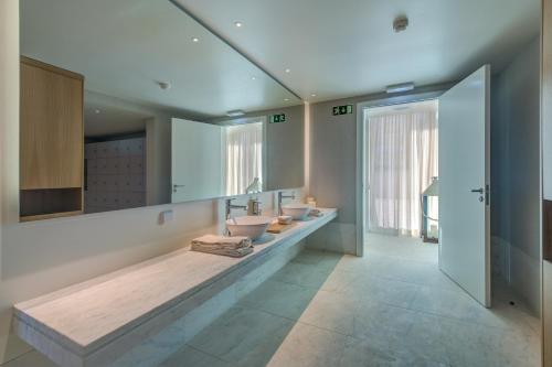 Un baño con dos lavabos y un espejo grande. en Bayline Condominium - Heated indoor Swimming pool - SPA - By Bedzy, en Armação de Pêra