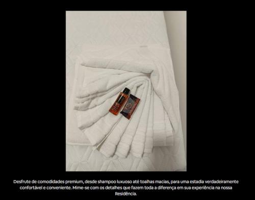 a white towel with a cell phone on top of it at Residencial Luce Del Sole - Apto Nº 2 in Joinville