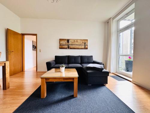 シュヴェリーンにあるAttraktive Wohnung im schönen Hinterhofの黒いソファとテーブルのあるリビングルーム