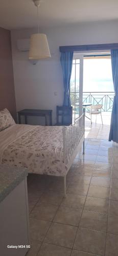 a bedroom with a bed and a view of the ocean at La Casa D' Irene in Agios Nikitas