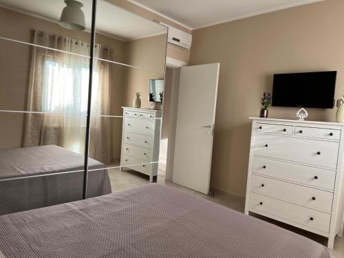 een slaapkamer met een bed en een dressoir met een televisie bij Villa Lucrezia in San Vito dei Normanni
