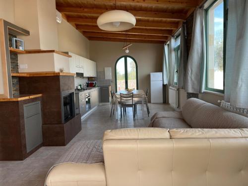 een woonkamer met een bank en een keuken met een tafel bij Villa Lucrezia in San Vito dei Normanni