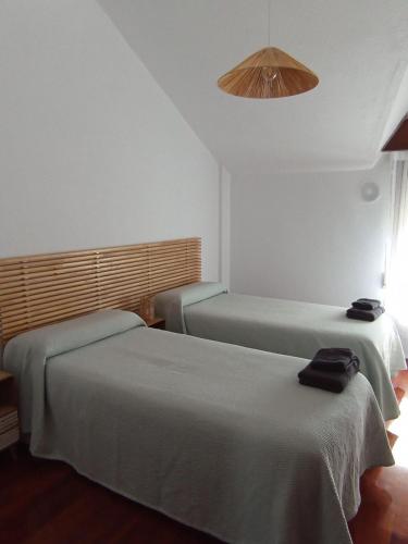 a hotel room with two beds and a light at La Casa de Boo in Boó de Piélagos