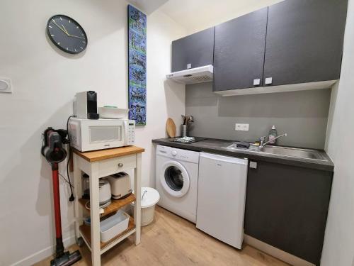 une cuisine avec un lave-linge et un micro-ondes dans l'établissement Appartement climatisation centre historique, à Aix-en-Provence