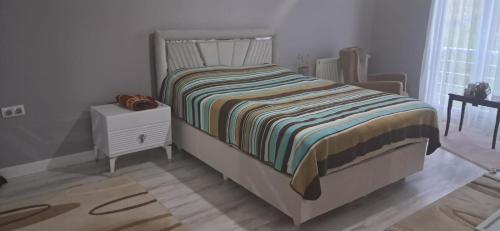 a small bedroom with a bed and a night stand at Villa Deluxe Panorama 61 in Trabzon