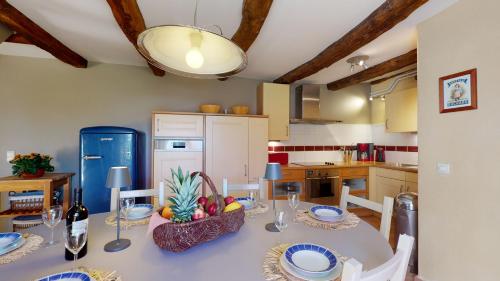 une salle à manger avec une table et une cuisine dans l'établissement Le Domaine des Fargues, à Sainte-Foy-de-Longas