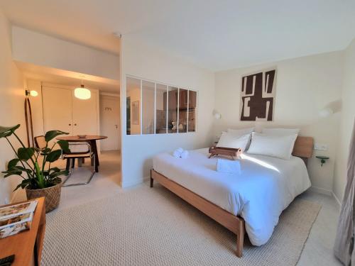 une chambre avec un grand lit blanc et une table dans l'établissement MAYU MAYU - cocon centre-ville climatisation, à Aix-en-Provence