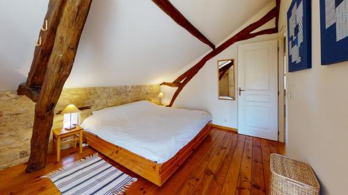 une chambre avec un grand lit dans un grenier dans l'établissement Le Domaine des Fargues, à Sainte-Foy-de-Longas