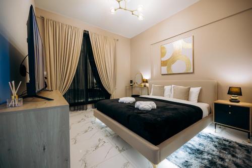 a bedroom with a large bed and a flat screen tv at Fabulous Brand New 1BR in Ras al Khaimah