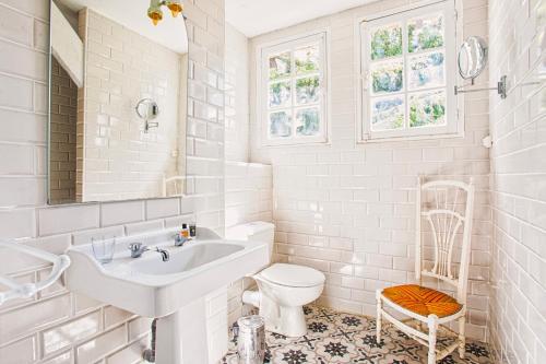 une salle de bain blanche avec un lavabo et des toilettes dans l'établissement Maison famille - Centre Ville - Jardin Botanique, à Cabourg